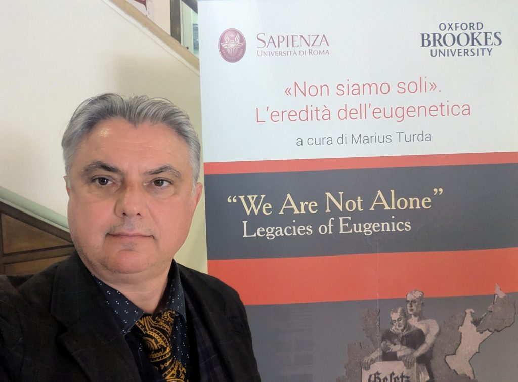 Professor Marius Turda with the exhibition sign for We Are Not Alone in Rome