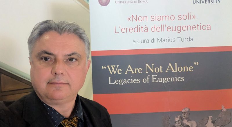 Professor Marius Turda with the exhibition sign for We Are Not Alone in Rome
